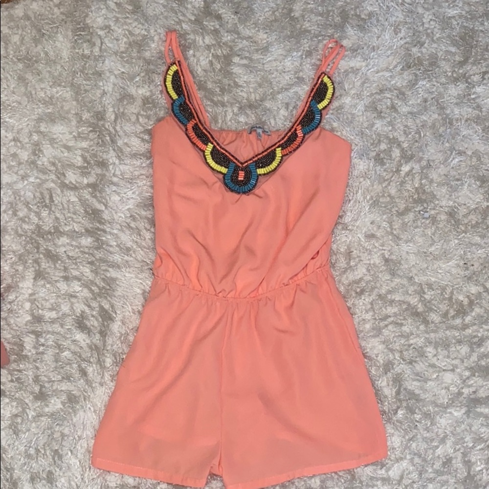 Coral romper with beading at top.